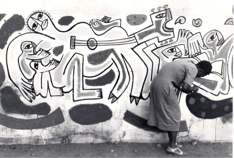Historische Aufnahme einer studentischen Hilfskraft bei der Arbeit
an César Olhagarays Wandbild Ohne Titel (Allegorie der
Unabhängigkeit von Moçambique) (1983)