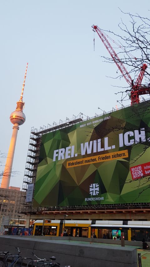 Billboard by the German Bundeswehr at Berlin’s Alexanderplatz, January 2026. ‘Frei. will. Ich.’is a wordplay evoking both the term ‘voluntary’ (freiwillig) and the phrase ‘I want free(dom)’. Photo: Eric Otieno Sumba